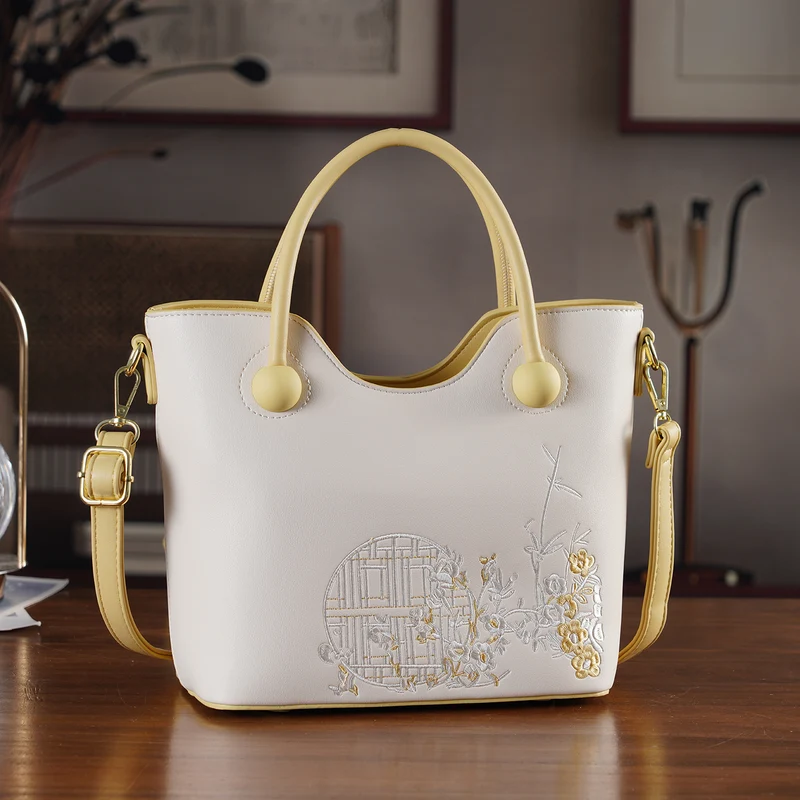 Kunstleder-Handtasche mit Tragegriffen und Umhängeriemen, florales Detail, Reißverschlussfächer, 30x22x11 cm, Gelb/Creme